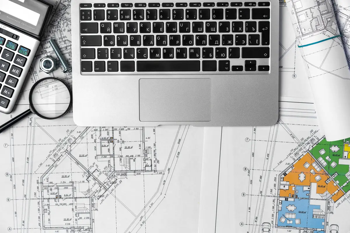 Working table of interior designer with blueprint and laptop