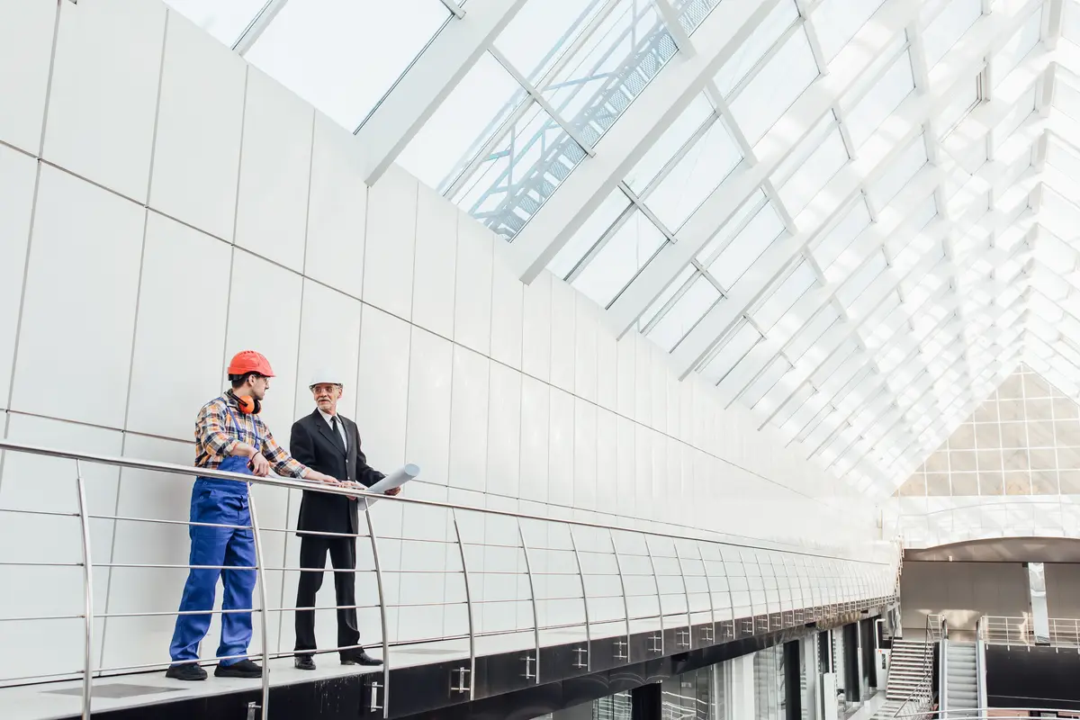 Standing industrial engineers in blue vests and helmets